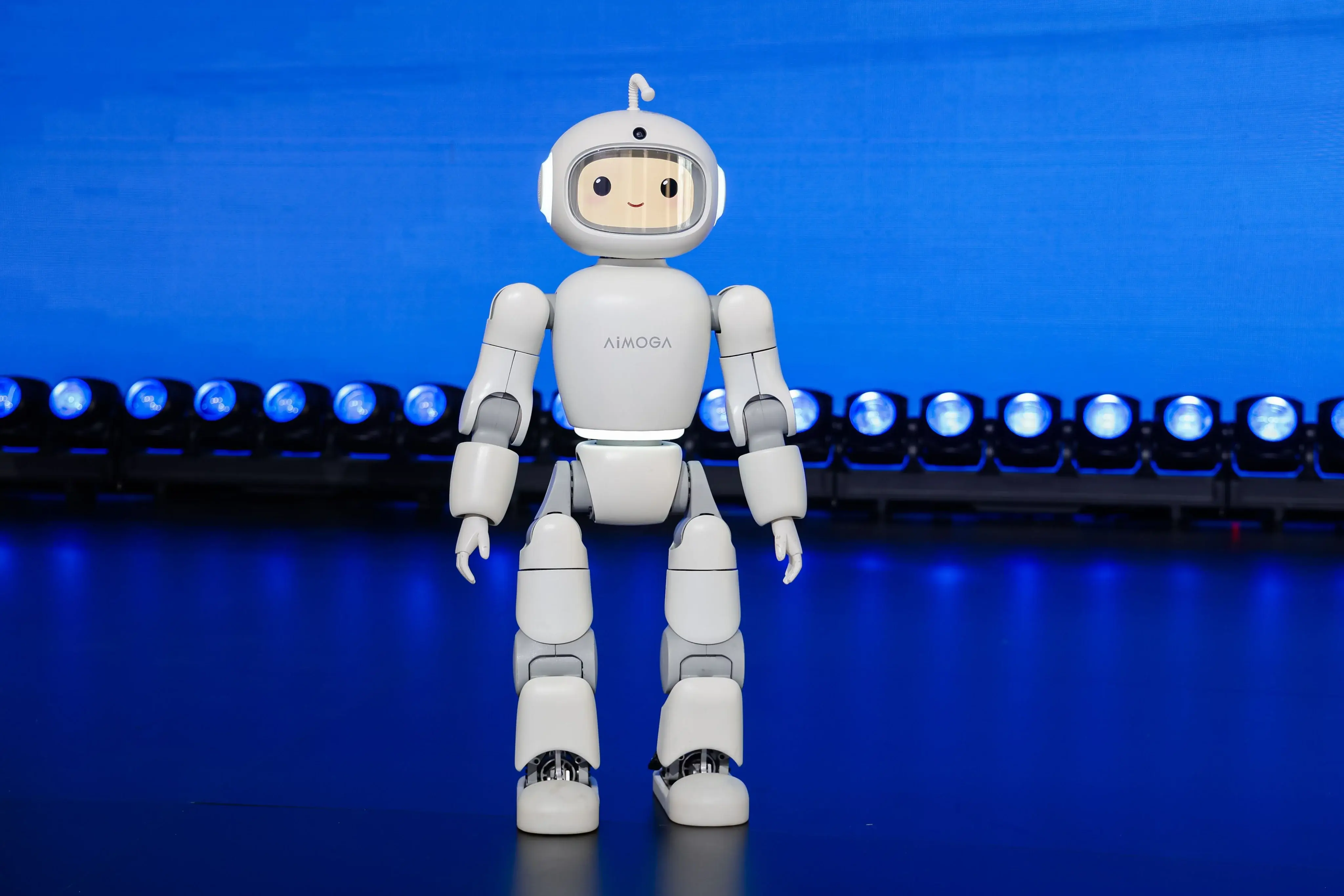 AiMOGA Mobo, a small white companion humanoid with a friendly face, on its launch stage.