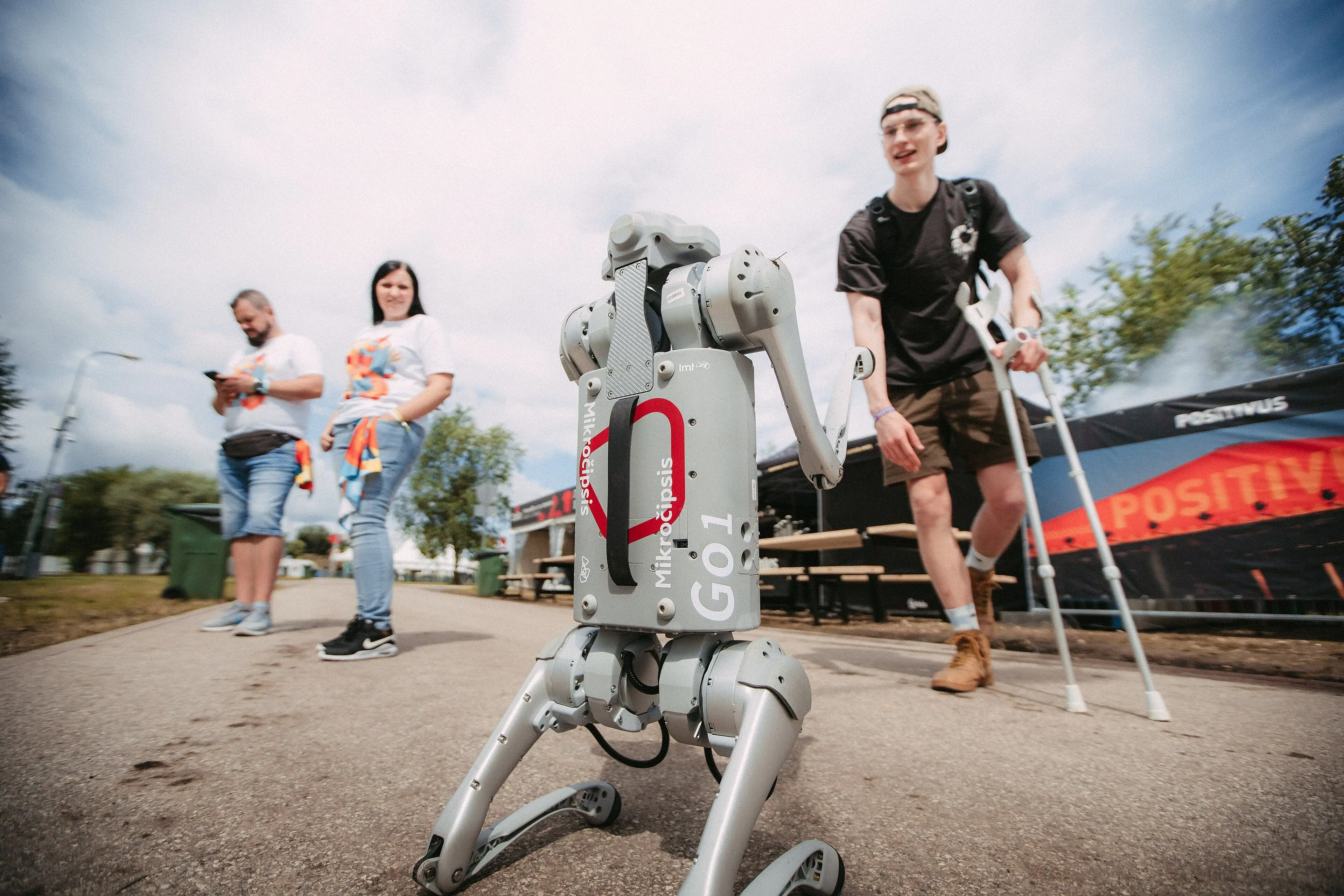 A grey Unitree Go1 quadruped rears upright during an outdoor public demonstration.