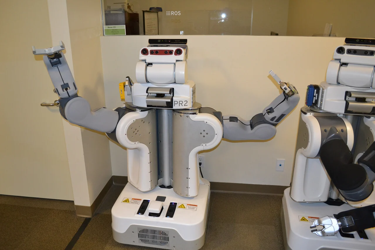 PR2 mobile research robot with two articulated arms and dexterous grasping hands.